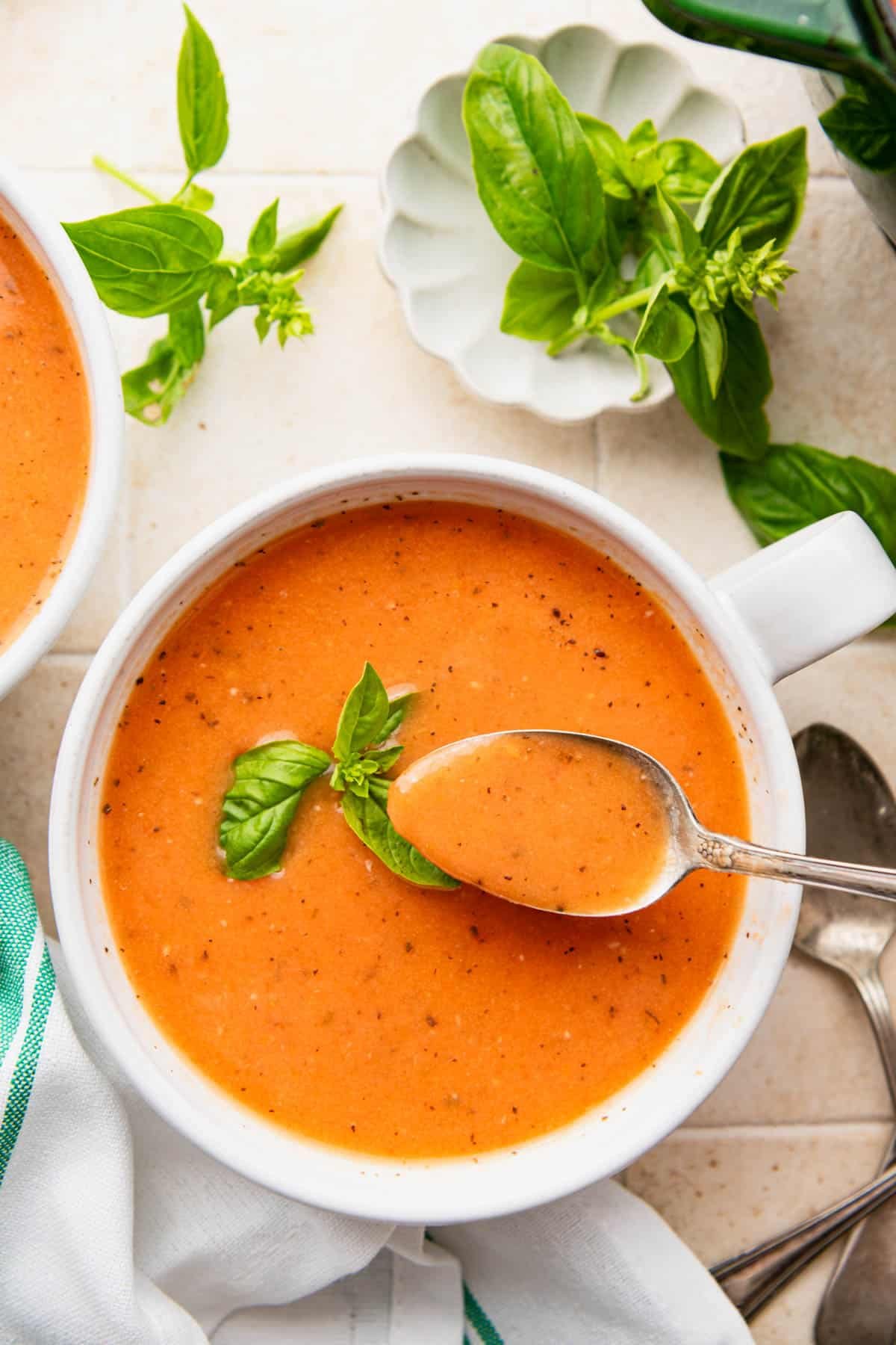 Overhead shot of a spoon taking a bite of tomato bisque from a bowl.