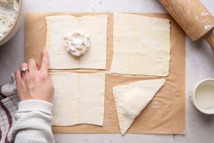 Lining the edges of the puff pastry with water.
