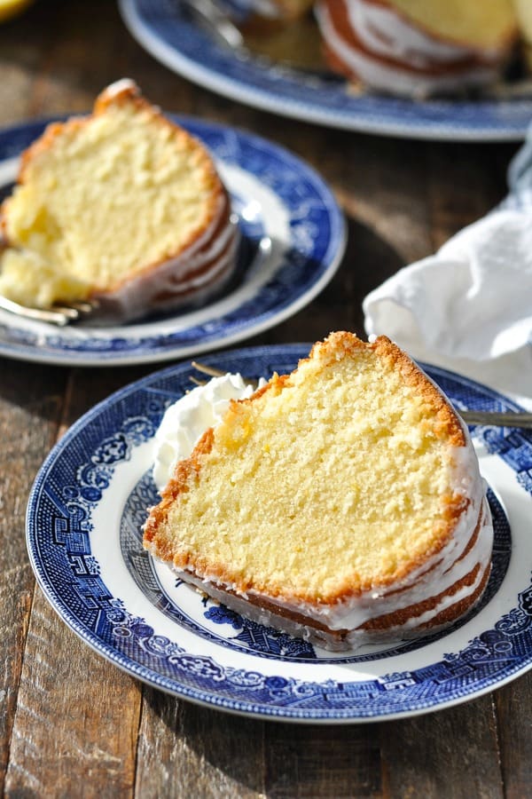Slice of 7-Up pound cake on a blue and white plate with whipped cream