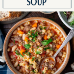 Spoon in a bowl of pasta e fagioli soup with text title box at top.