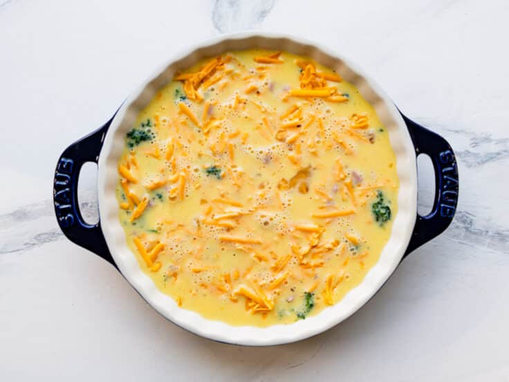 Pouring the egg custard over the fillings.