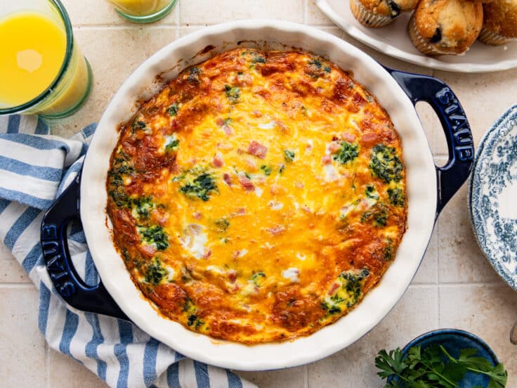 Horizontal overhead shot of a baked crustless spinach quiche on a table.