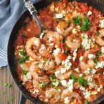 Close overhead shot of Baked Shrimp with Tomatoes and Feta in a cast iron skillet