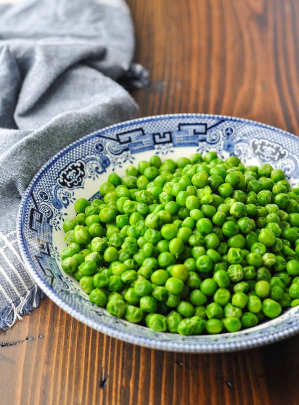 Cooked frozen peas in a serving bowl