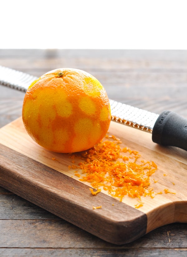 Zesting an orange on a cutting board