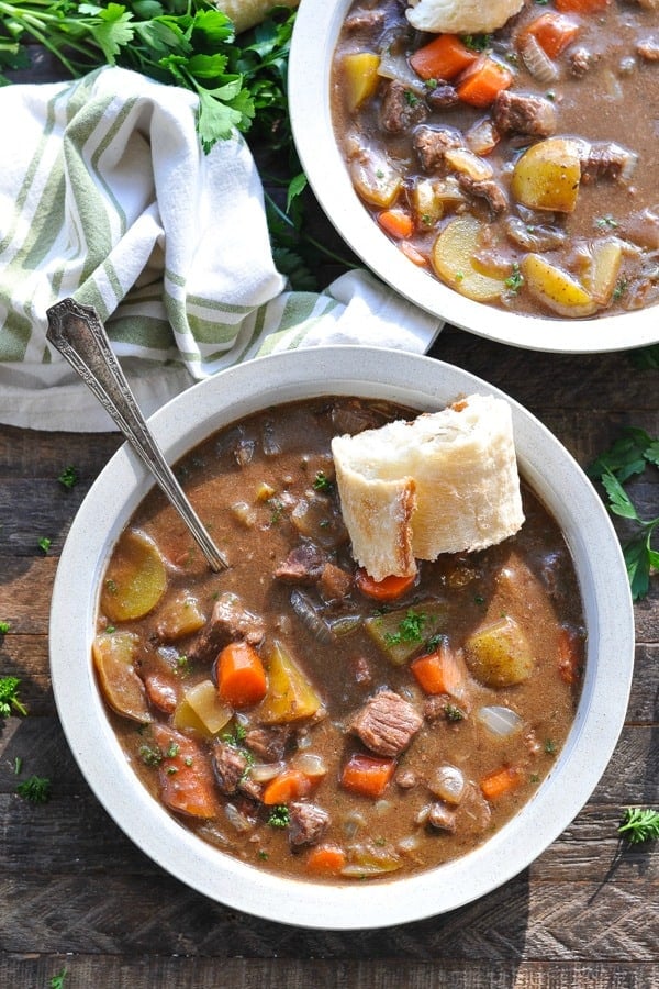 Overhead shot of a bowl of Irish Stew on a wooden surface