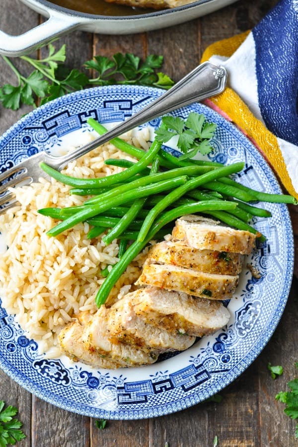 Close overhead shot of a plate of oven baked chicken breast with rice and green beans