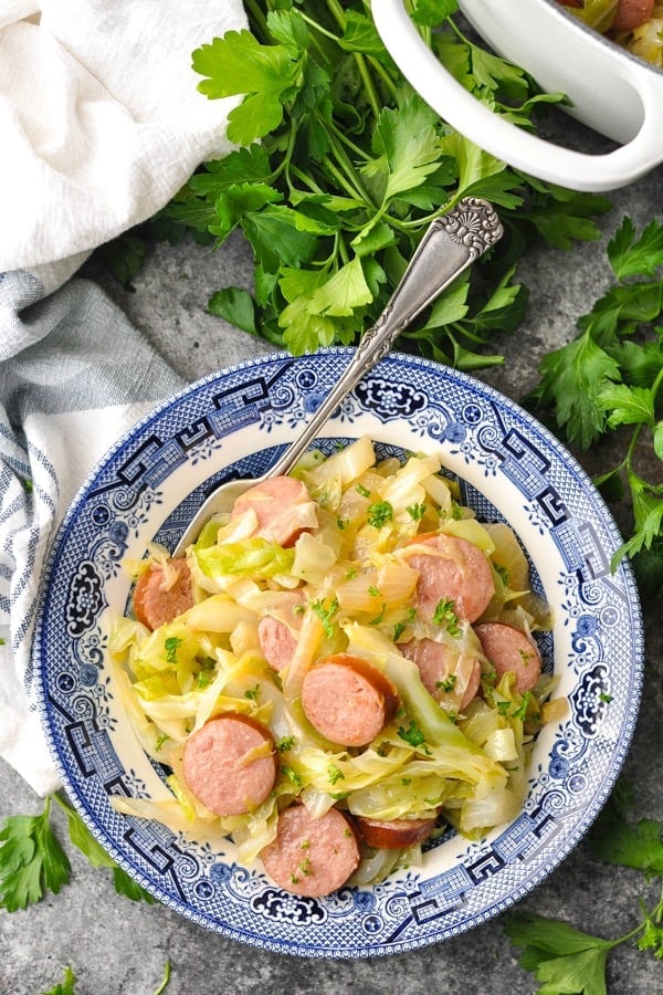 Overhead shot of a bowl of sausage and cabbage with a fork