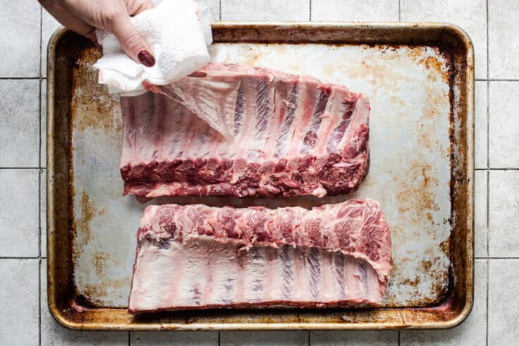 Process shot showing how to remove the membrane from the back of baby back ribs.