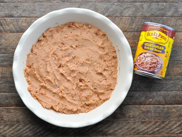 Spreading refried beans in dish for 7 layer bean dip