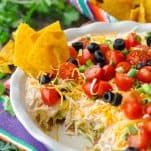 Front shot of Mexican 7 layer taco dip on a striped placemat
