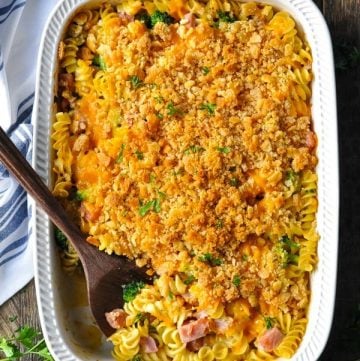Overhead shot of ham cheese and broccoli casserole in a white baking dish on a wooden table