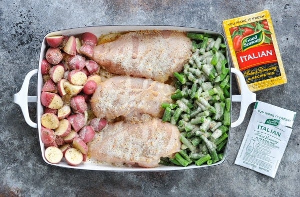 Italian chicken and potatoes with green beans in a casserole dish before baking