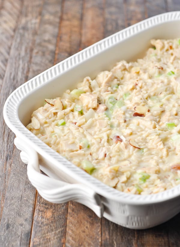 Chicken and rice casserole filling in a white baking dish