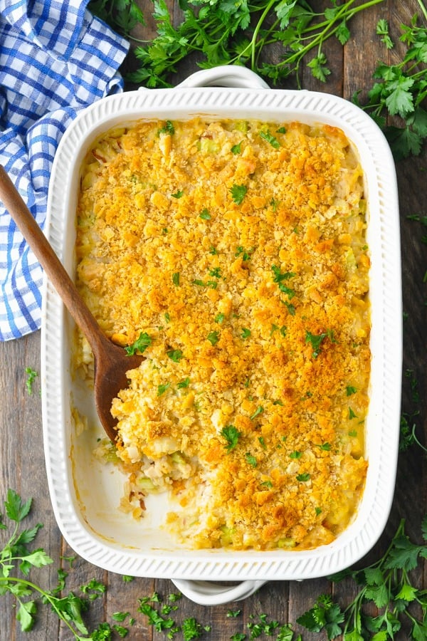 Overhead image of baked chicken and rice casserole with a wooden serving spoon