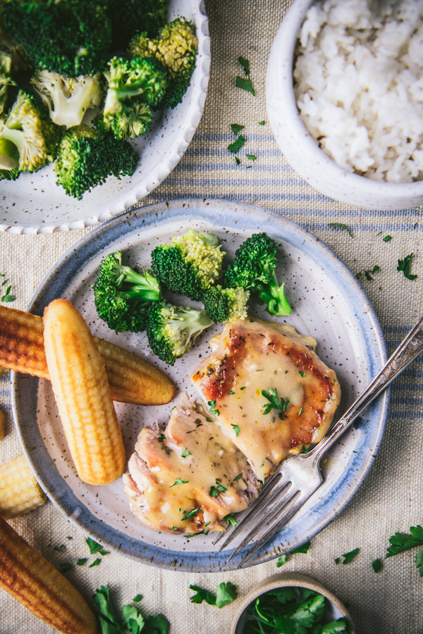 Overhead image of slow cooker ranch pork chops on a plate with cornbread and vegetables
