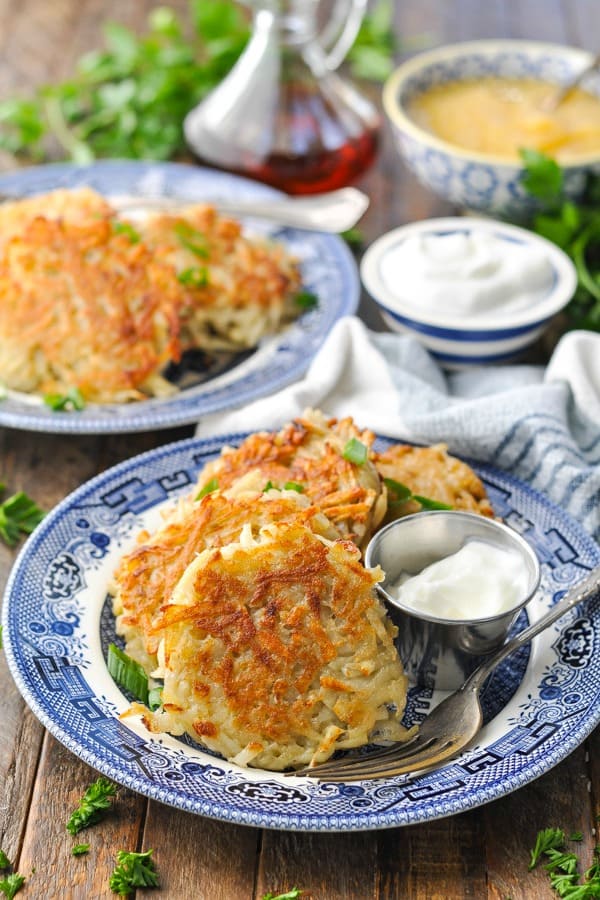 Image of potato pancakes on a blue and white plate on a wooden surface