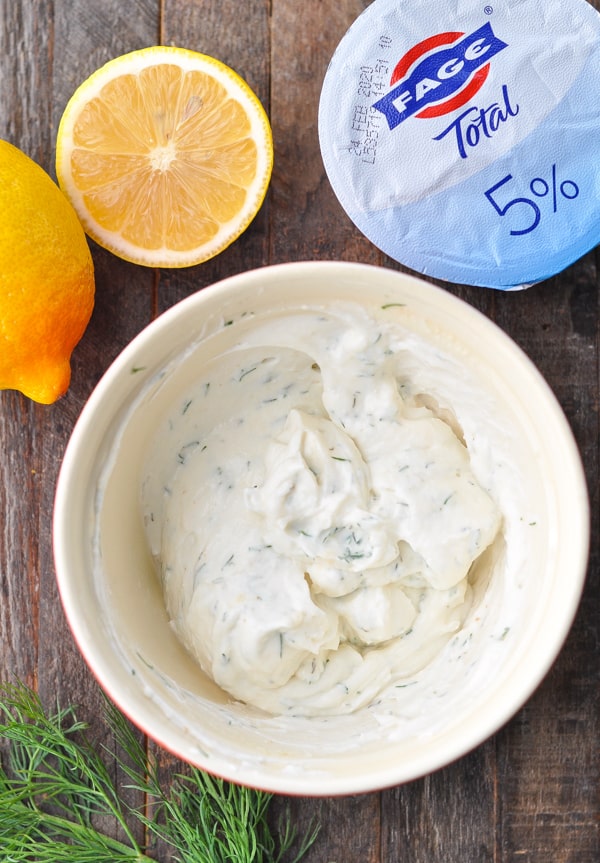 A bowl of creamy dill sauce made with Fage yogurt, lemon juice, and fresh dill.
