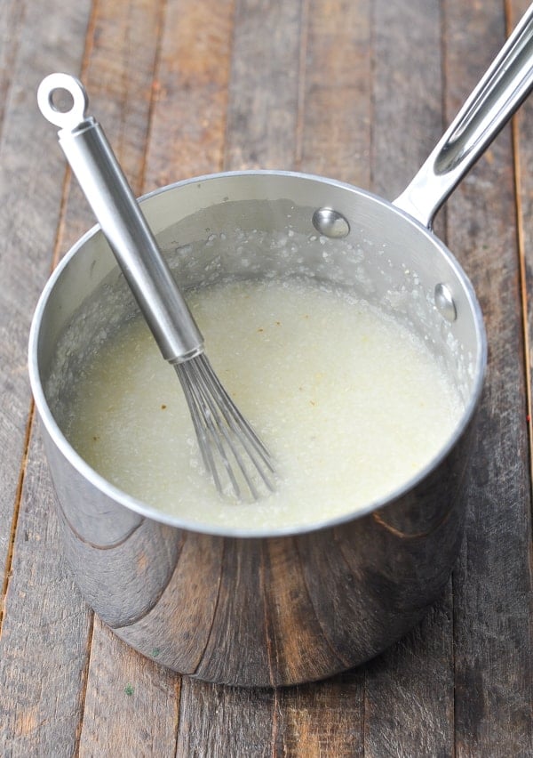 Grits in a saucepan with a whisk