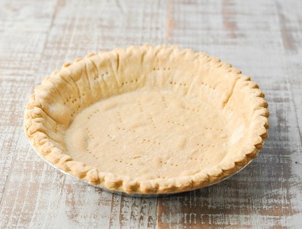 Baked pie crust on a white wooden surface
