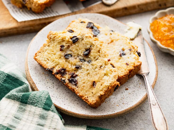 Horizontal side shot of slices of Irish soda bread on a plate.