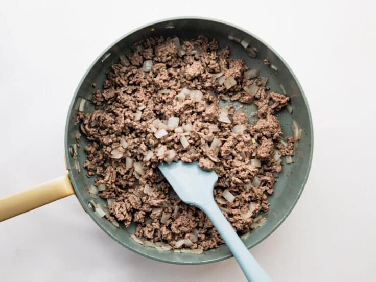 Cooking ground beef and onion in a skillet.