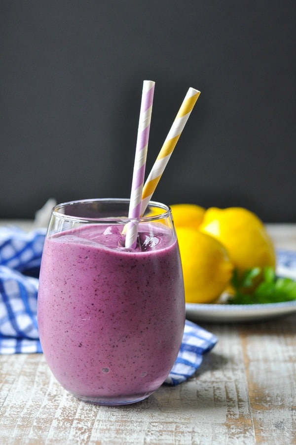 Front shot of blueberry banana smoothie on a white surface with black background
