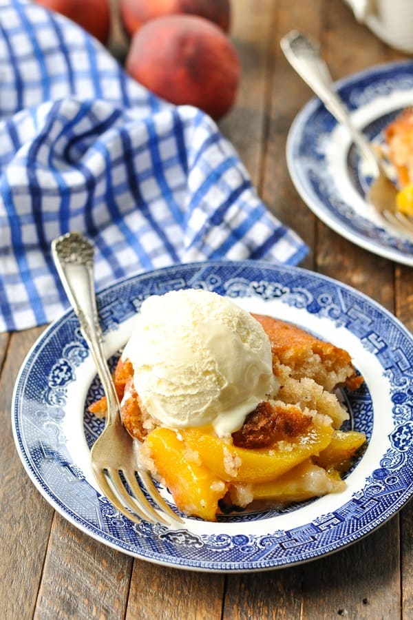 Serving of bisquick peach cobbler on a blue and white plate