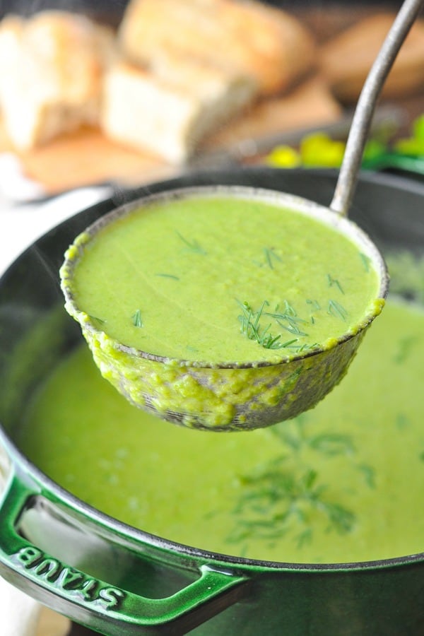 Front shot of a ladle scooping up Creamy Asparagus Soup