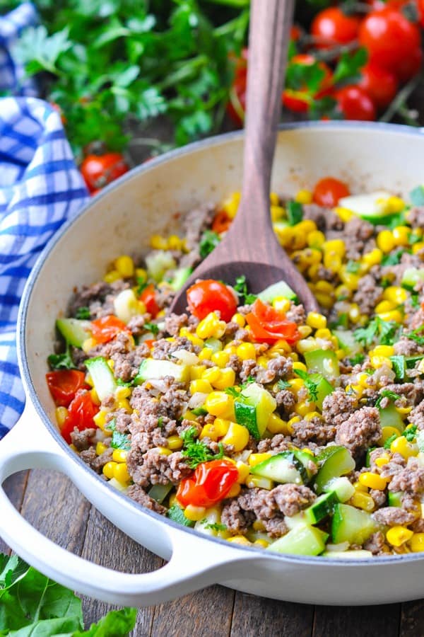 Front shot of ground beef in a skillet with summer vegetables