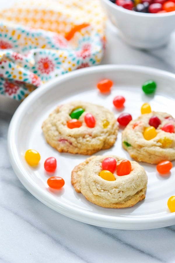 Jelly bean cookies on a white plate on a white marble surface