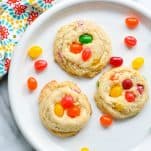 Close overhead shot of three jelly bean cookies on a white plate