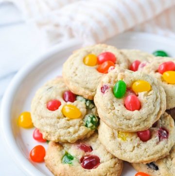 Close up front shot of white plate piled high with jelly bean cookies