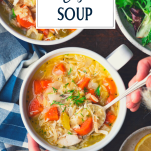 Overhead shot of hands eating a bowl of lemon chicken soup with orzo and text title overlay