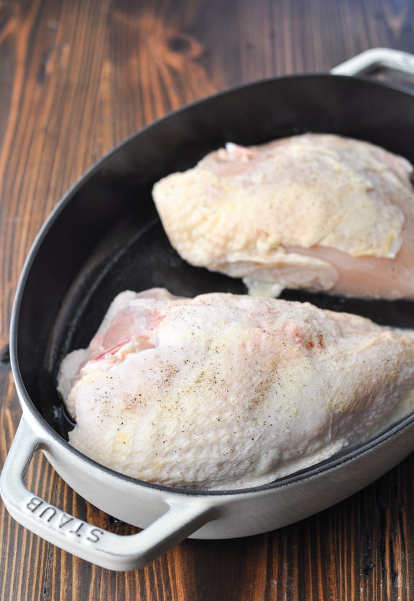 Bone in skin on chicken breasts in a cast iron dish