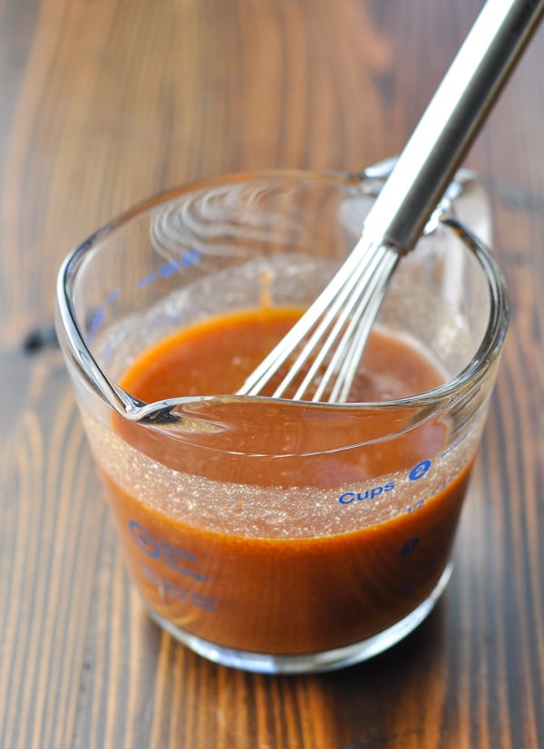 Homemade barbecue sauce in a glass mixing bowl with whisk