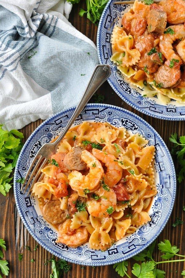 Overhead shot of a bowl of shrimp and sausage pasta on a wooden table