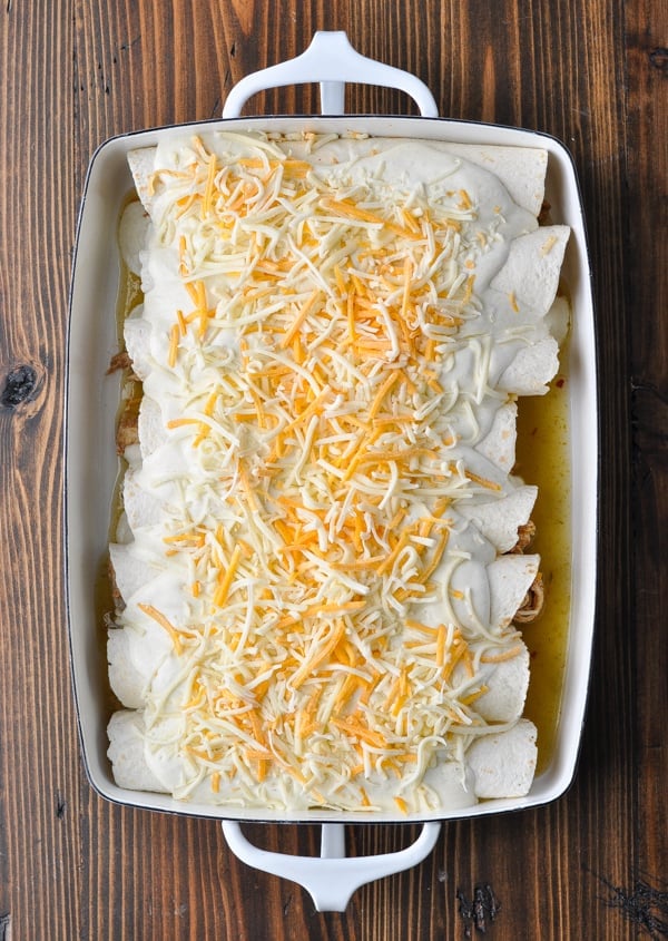 Sour cream chicken enchiladas in a white dish before baking in the oven