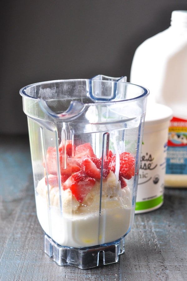 Ingredients for strawberry banana smoothie in a blender