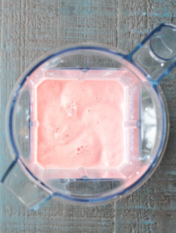 Overhead shot of pureed strawberry banana smoothie in blender