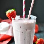 Strawberry Banana Smoothie garnished with a fresh strawberry on the glass