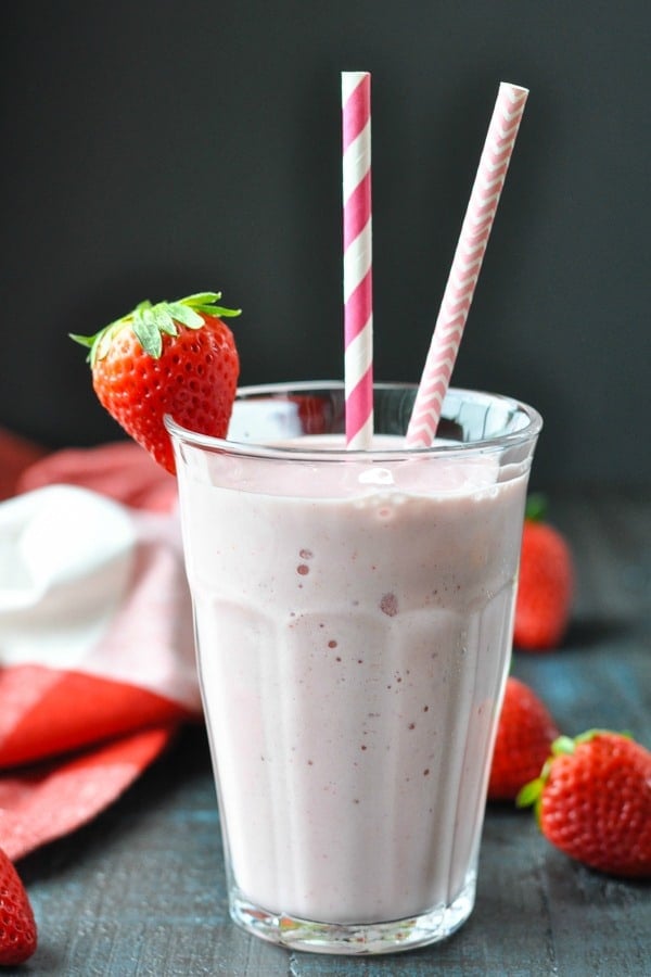 Strawberry Banana Smoothie garnished with a fresh strawberry on the glass
