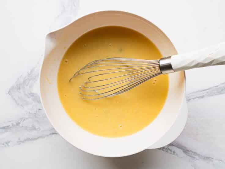 Whisking together the sauce ingredients in a mixing bowl.