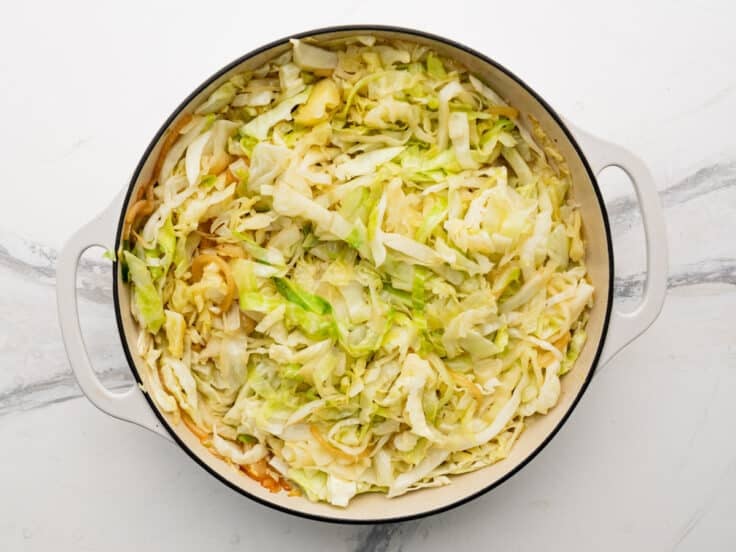 Fried, tender cabbage in a skillet.