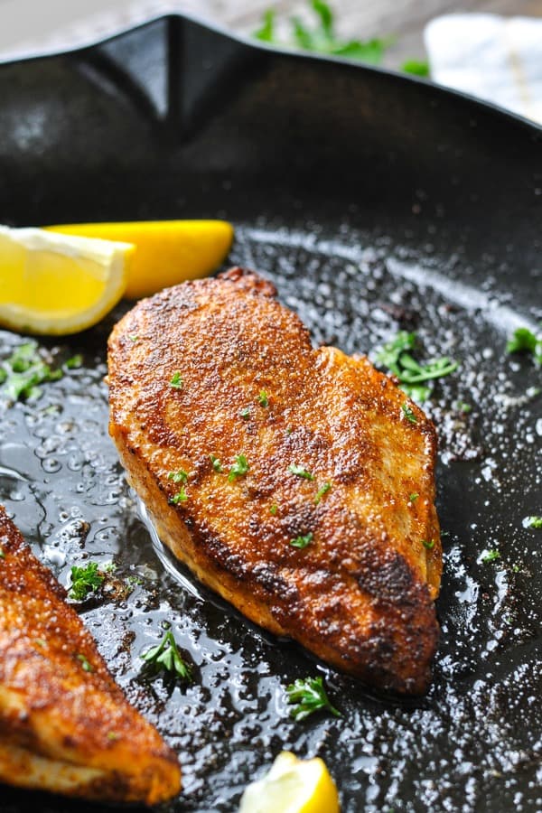 Front shot of a blackened chicken breast in a cast iron skillet