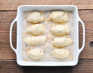 Overhead shot of chicken crescent rolls in a white baking dish before going in the oven