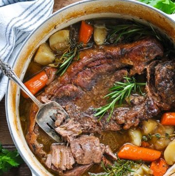 Overhead image of a fork in a dutch oven pot roast with gravy