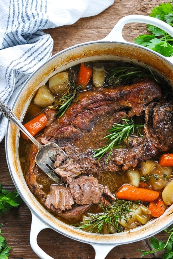 Overhead image of a fork in a dutch oven pot roast with gravy