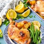 Side shot of greek roasted chicken on a plate with green beans