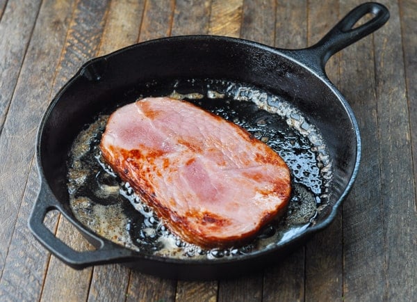 Pan frying ham steak in a cast iron skillet